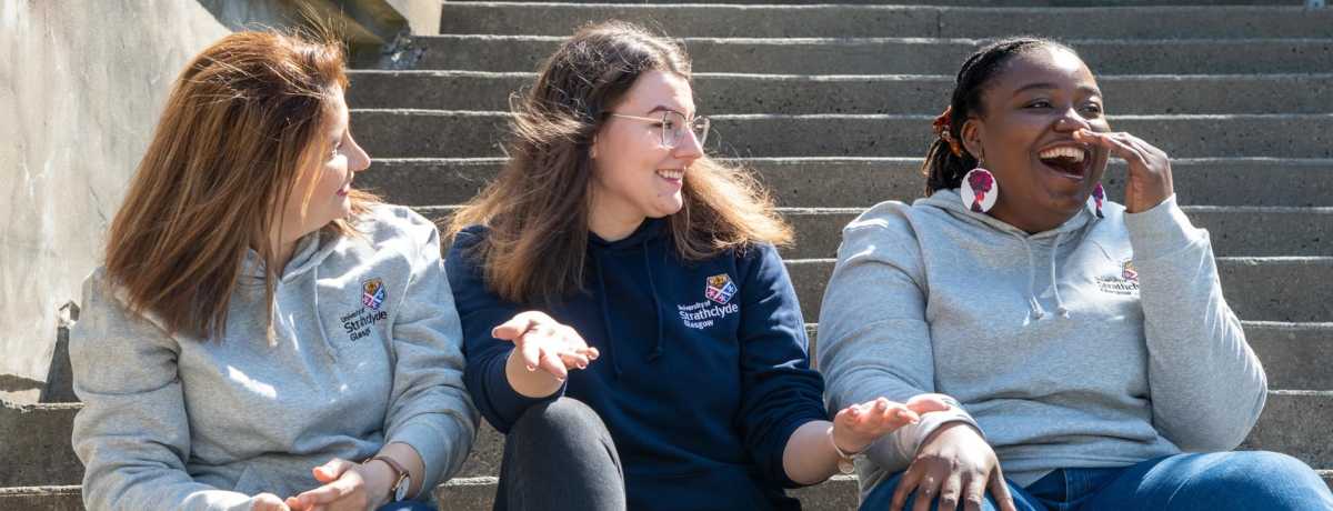 Students wearing merchandise laughing and smiling